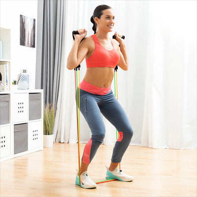 Femme faisant un squat avec elastique musculation à la maison.