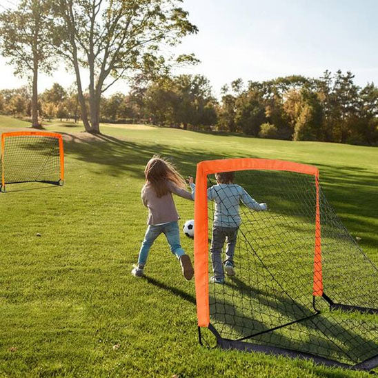 deux enfants avec ballon jouent entre deux cage de foot