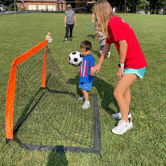 mere et fils avec ballon derriere la cage de foot