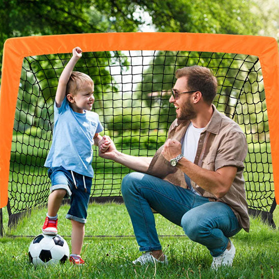 pere et fils contant davant une cage de foot
