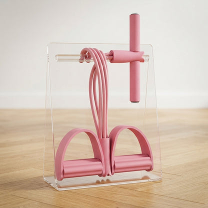 Élastique musculation rose avec pédales suspendu sur présentoir transparent clair.