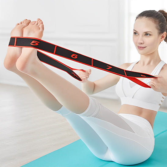 Femme assise sur tapis jambe tendue utilisant un élastique musculation