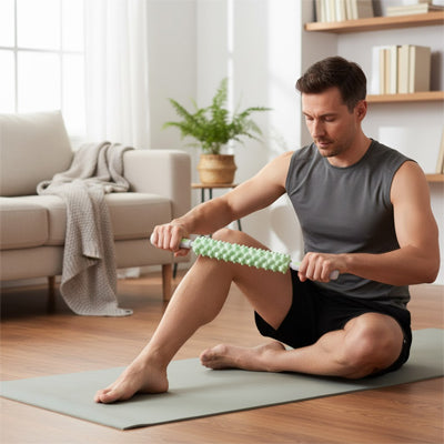 Homme massant  jambe avec rouleau de massage sur un tapis