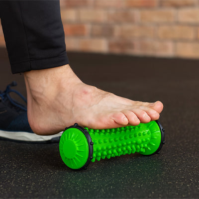 Pied posé sur rouleau de massage  exercice de récupération plantaire.