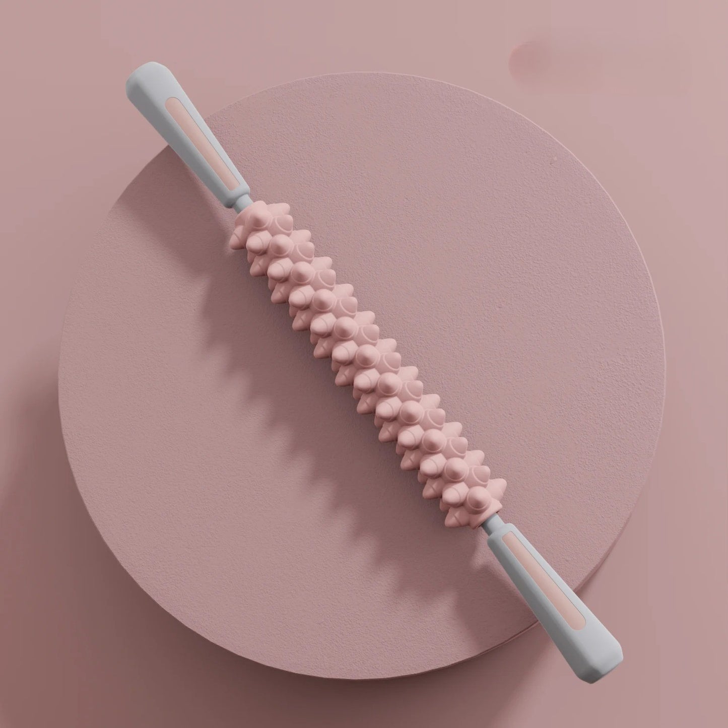 Rouleau de massage rose avec poignées grises fond rose