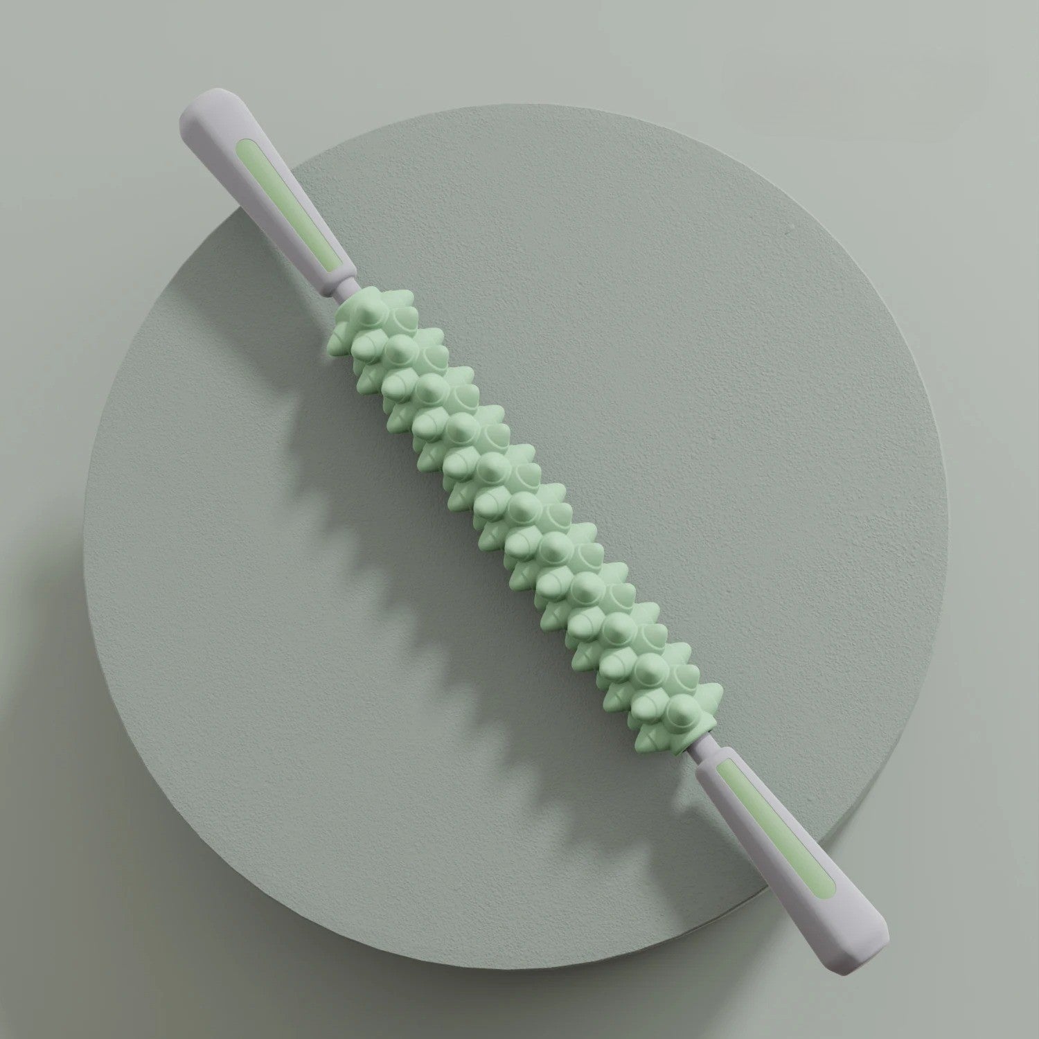 Rouleau de massage vert à poignées, socle gris circulaire