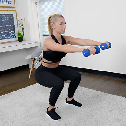 femme effectue des squats entenant des halteres hexagonales dans une salle de sport