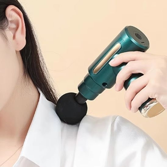 Gros plan d’un pistolet de massage sur l’épaule d’une femme