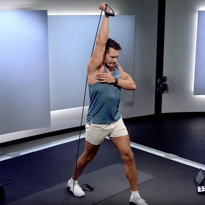 Homme réalisant extension triceps avec un élastique musculation en studio.