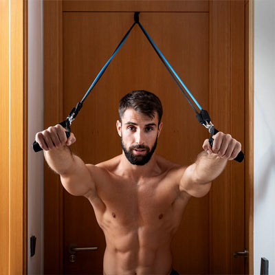 Homme s'entraînant avec elastique musculation fixée à une porte