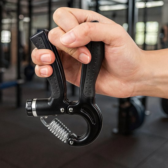 Main serrant un hand grip dans une salle de sport.
