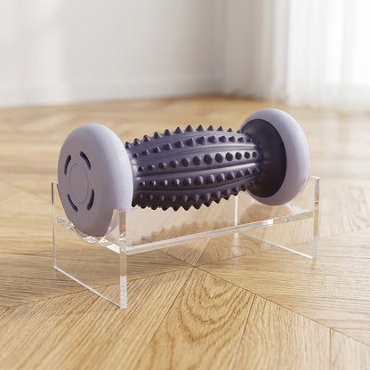 rouleau de massage gris sur présentoir transparent posé sur parquet.