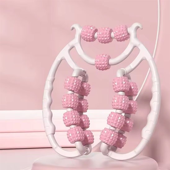 Rouleaux de Massage roses posé sur un support rose clair.