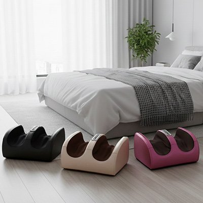 Trois appareils masseur pieds  colorés disposés au pied d’un lit moderne.