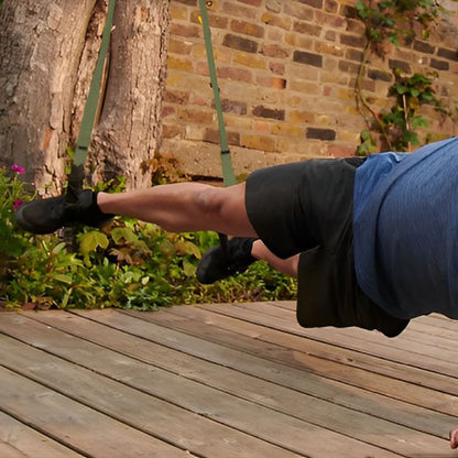 Un homme réalise un gainage suspendu utilisant une sangle musculation.