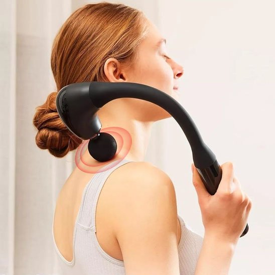 Une Femme utilisant un pistolet de massage incurvé pour sa nuque.
