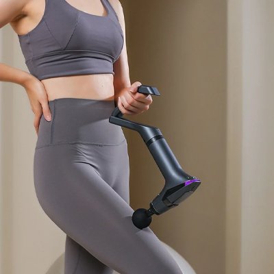 Une femme utilise un pistolet de massage sur sa cuisse.