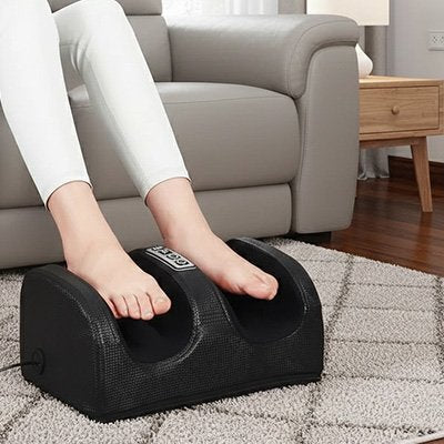 Une Personne assise utilise appareil masseur de pieds noir dans salon moderne.